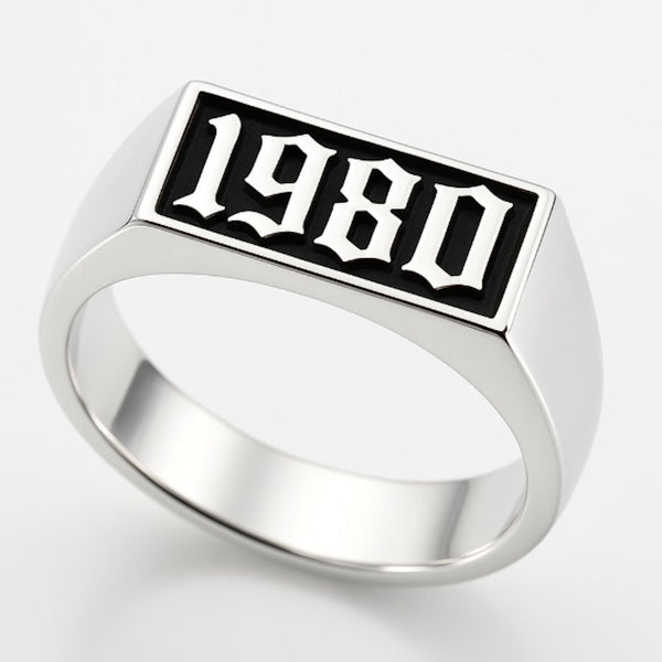 Silver ring with '1980' engraving on a white background