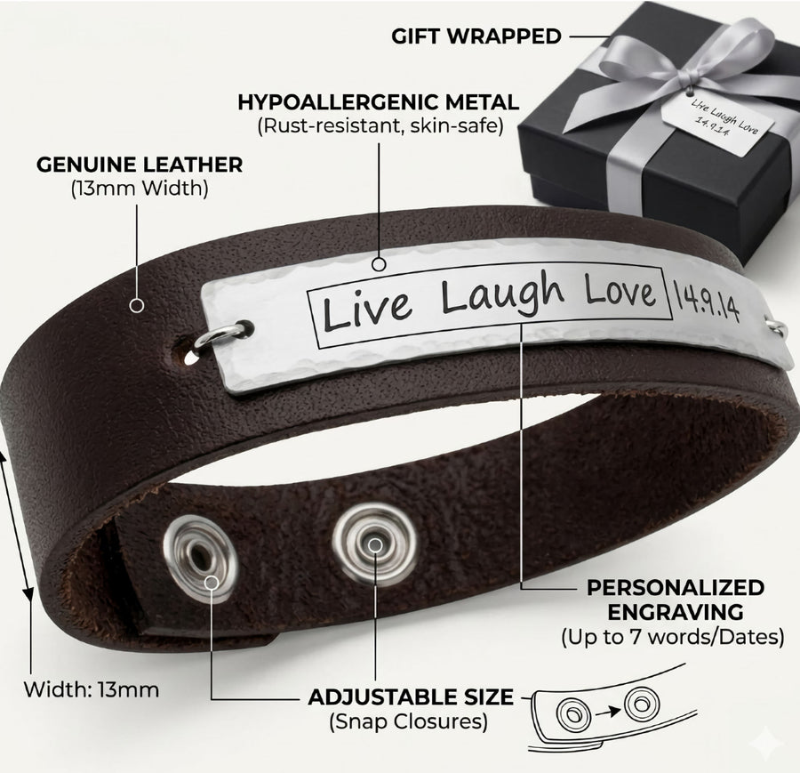A black leather bracelet with a custom engraved message 'Live Laugh Love 1981' on a white metal plate, featuring two metal eyelets for adjustability.