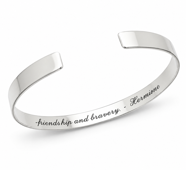 A polished silver cuff bracelet engraved with the quote 'friendship and bravery - Hermione' in black script, shown on a clean white background.