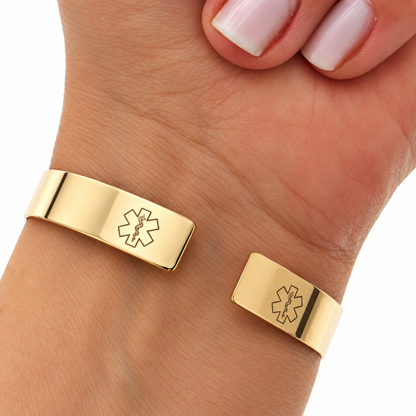 Two gold-toned metal cuff bracelets with engraved Star of Life symbols, shown worn on a person's wrist and hand against a white background.