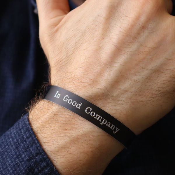 Black band with 'In Good Company' text on a wrist