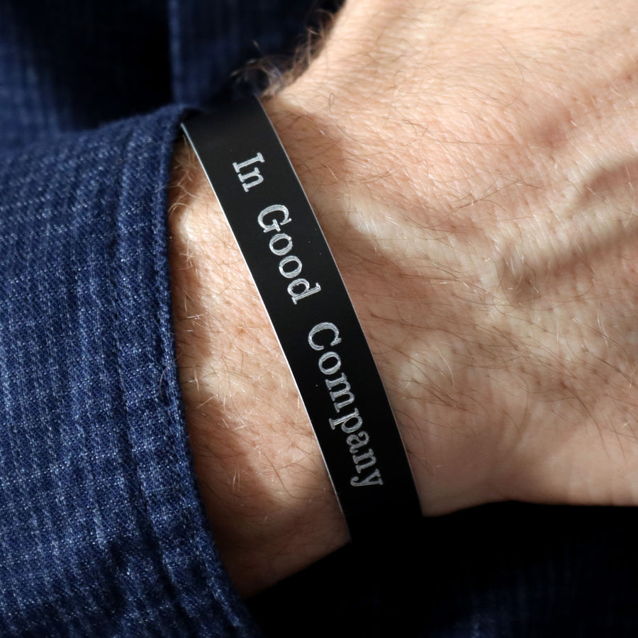 Black band with 'In Good Company' text on a wrist