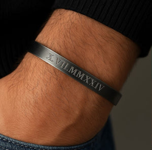 Black bracelet with Roman numeral engraving on a wrist  