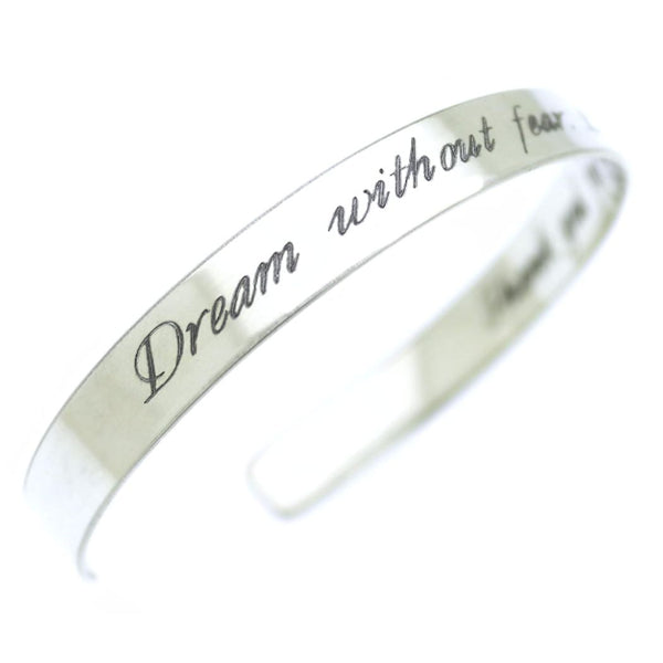 Silver bracelet with 'Dream without fear' engraving on a white background